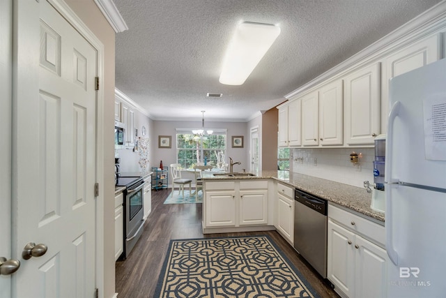 kitchen featuring stainless steel appliances, decorative light fixtures, white cabinets, and kitchen peninsula