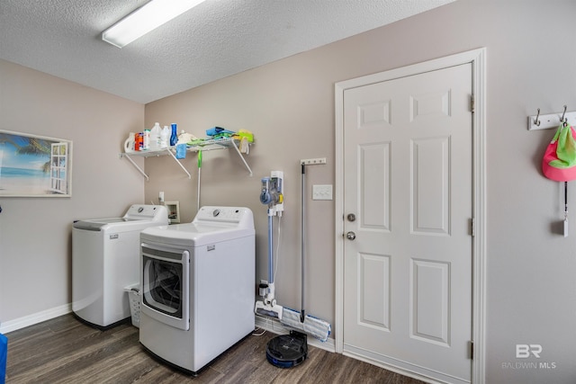 clothes washing area with dark hardwood / wood-style floors, washer and dryer, and a textured ceiling