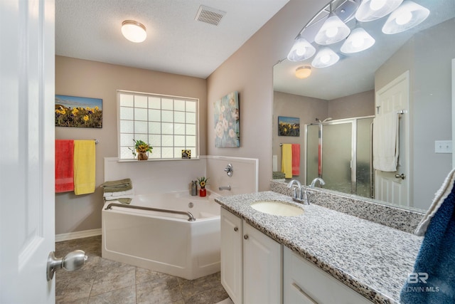 bathroom featuring vanity, separate shower and tub, tile patterned flooring, and a textured ceiling