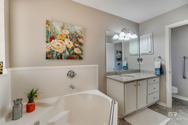 bathroom featuring vanity, a washtub, and toilet