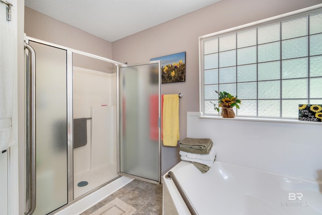 bathroom featuring plus walk in shower and a textured ceiling