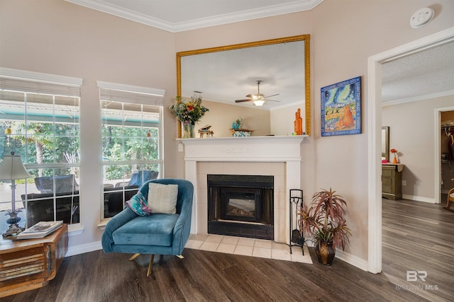 sitting room with hardwood / wood-style flooring, ornamental molding, and a tile fireplace