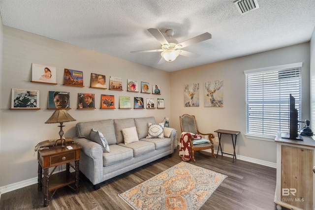 living room featuring a textured ceiling, dark hardwood / wood-style floors, and ceiling fan