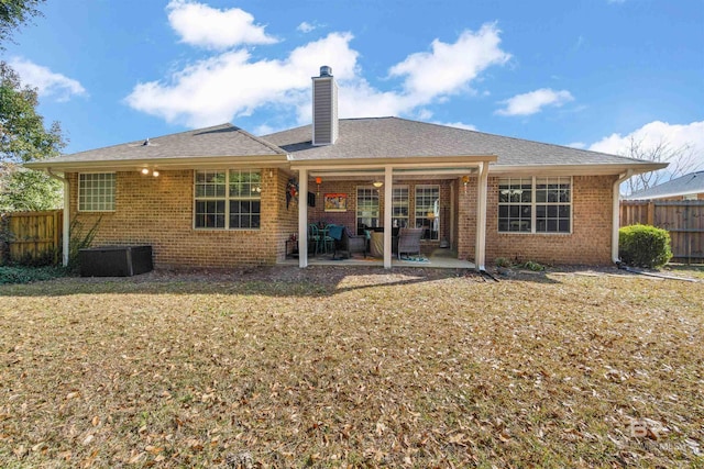 rear view of property with central AC unit, a lawn, and a patio area