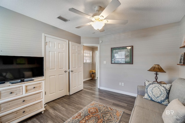 interior space featuring ceiling fan, dark hardwood / wood-style floors, and a textured ceiling