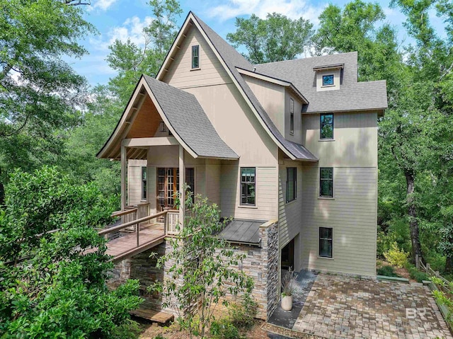 view of front facade with a wooden deck, a patio area, and french doors