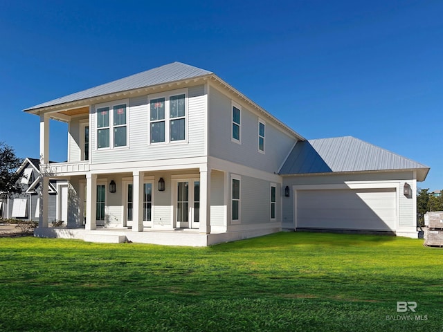 view of front of home featuring covered porch, a front yard, and a garage