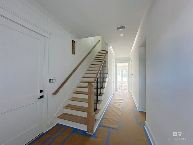 stairway featuring crown molding and carpet flooring