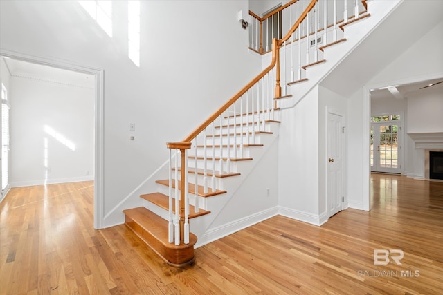 stairs featuring a high ceiling and hardwood / wood-style floors