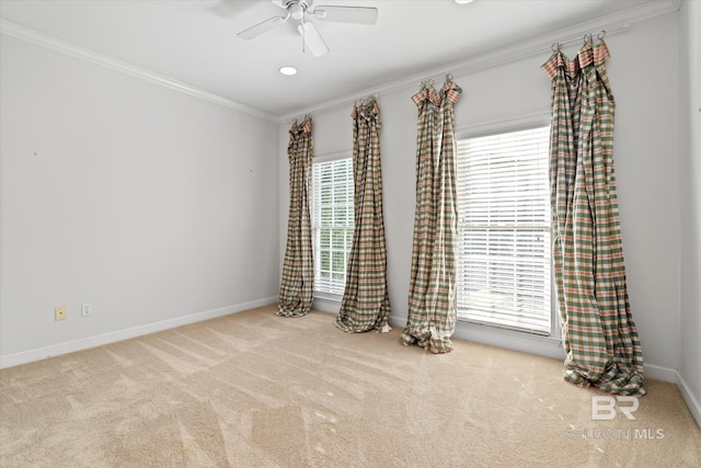 unfurnished room with light carpet, crown molding, a wealth of natural light, and ceiling fan