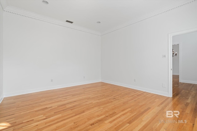 spare room with ornamental molding and light hardwood / wood-style flooring