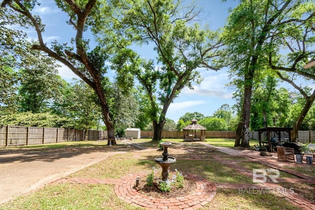 41 Yester Pl, Mobile, AL 36608 - view of yard featuring a patio, an outdoor structure, a storage unit, a fenced backyard, and a gazebo