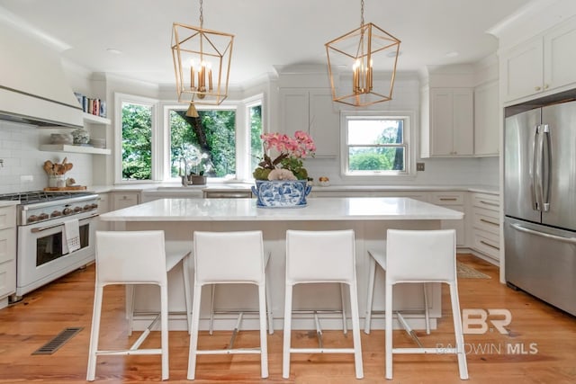 41 Yester Pl, Mobile, AL 36608 - kitchen featuring decorative backsplash, light countertops, stainless steel refrigerator, high end range, and a notable chandelier