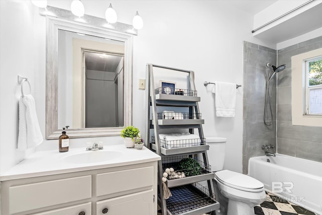 full bathroom featuring tiled shower / bath, vanity, and toilet