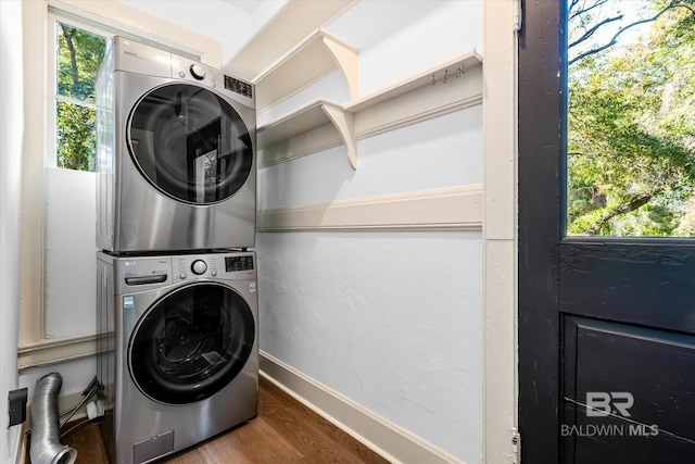 washroom with stacked washer and dryer, plenty of natural light, and hardwood / wood-style floors