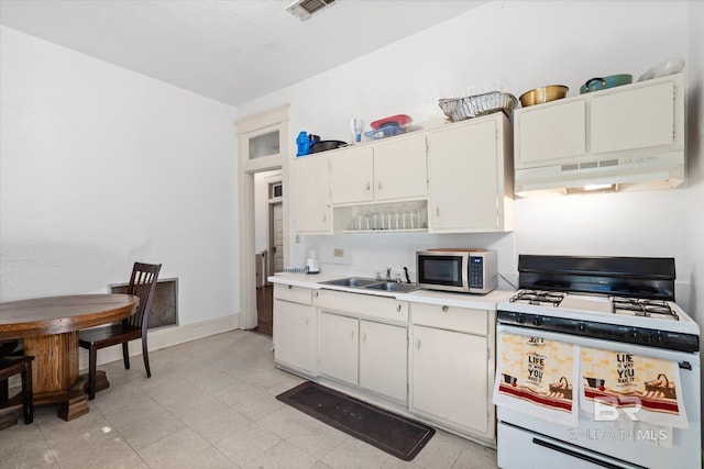 kitchen with light tile patterned floors, white range with gas cooktop, sink, and white cabinets