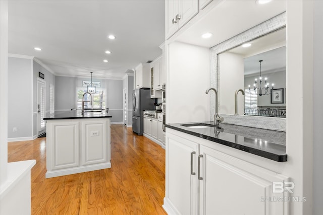 kitchen with white cabinets, light wood-type flooring, and sink