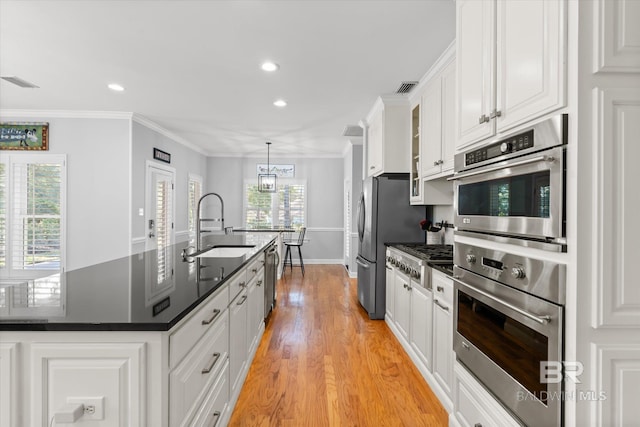 kitchen with plenty of natural light, white cabinetry, and sink