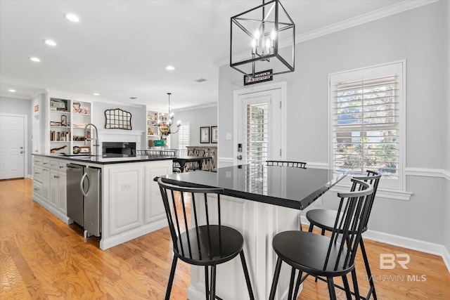 kitchen with a center island, white cabinets, pendant lighting, and light hardwood / wood-style flooring