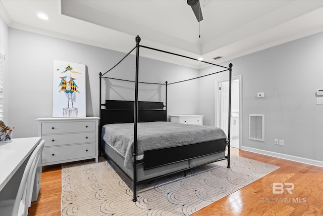 bedroom featuring ceiling fan, light hardwood / wood-style flooring, ensuite bathroom, and ornamental molding