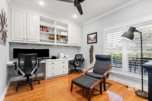 office with built in desk, light hardwood / wood-style flooring, ceiling fan, and crown molding