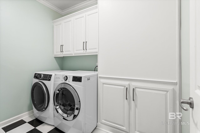 laundry room featuring cabinets, crown molding, and washing machine and dryer