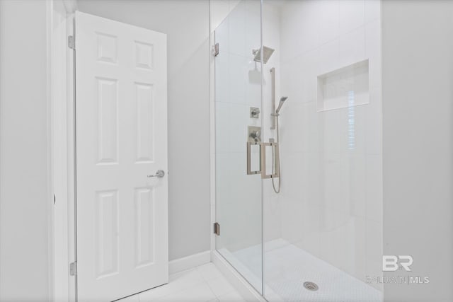 bathroom with tile patterned flooring and a shower with shower door