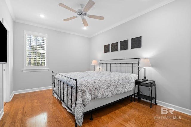 bedroom featuring hardwood / wood-style flooring, ceiling fan, and crown molding