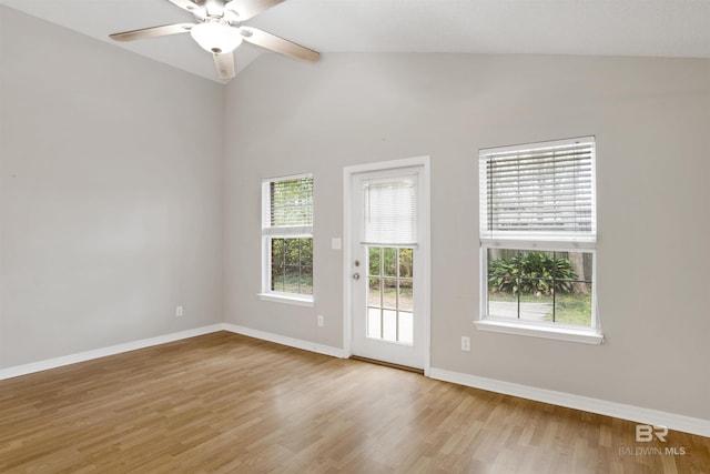 empty room featuring lofted ceiling, light wood-style flooring, and baseboards