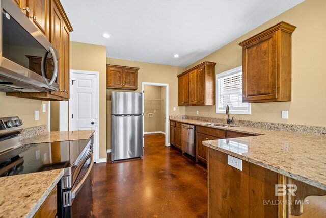 kitchen featuring stainless steel appliances, sink, and light stone counters