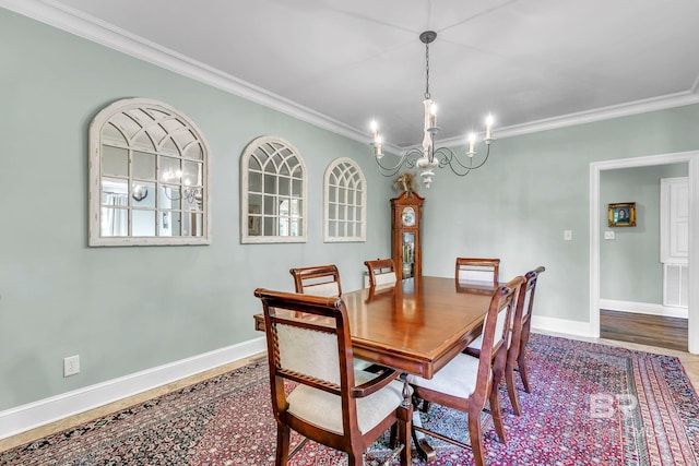 dining space with an inviting chandelier, crown molding, wood finished floors, and baseboards