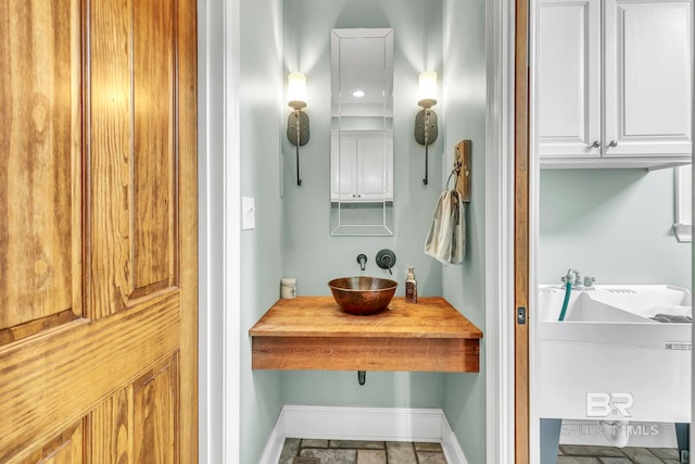 bathroom featuring baseboards and a sink