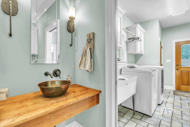 laundry room with baseboards, plenty of natural light, separate washer and dryer, and a sink