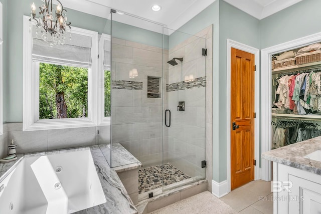 bathroom with tile patterned floors, a jetted tub, an inviting chandelier, and a shower stall