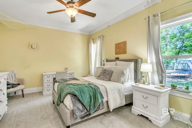 bedroom featuring ceiling fan, baseboards, and multiple windows
