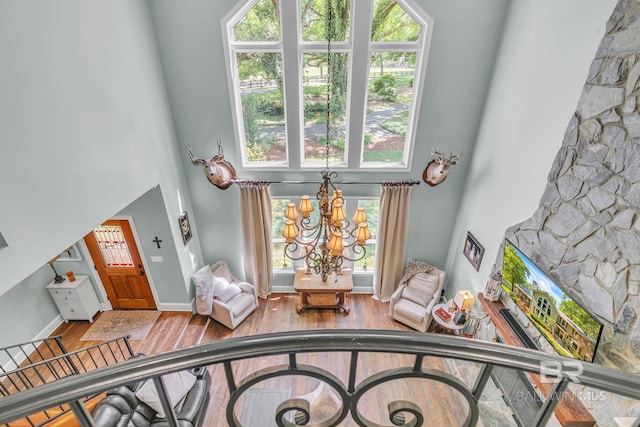 living area featuring hardwood / wood-style flooring, a towering ceiling, and a notable chandelier
