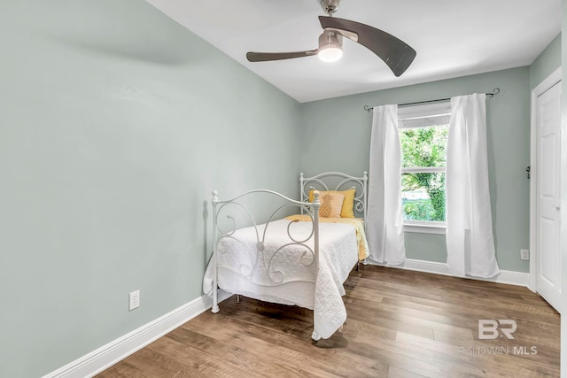 bedroom with baseboards, a ceiling fan, and wood finished floors