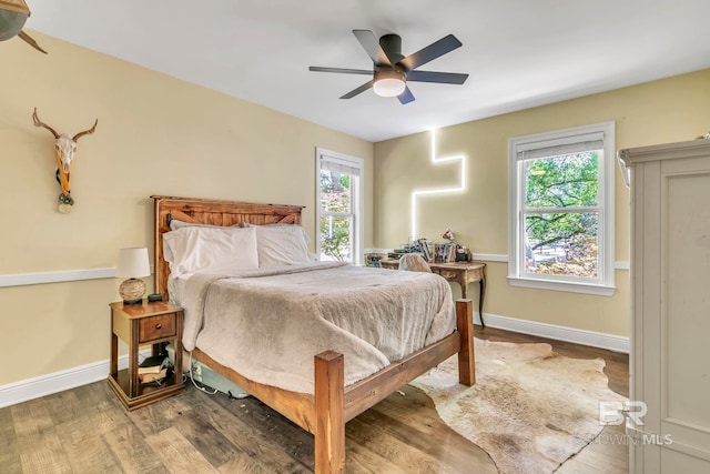 bedroom with baseboards, wood finished floors, and ceiling fan