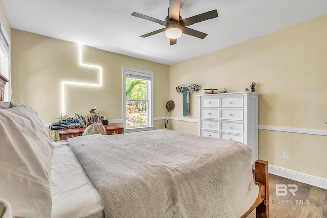 bedroom featuring baseboards, a ceiling fan, and wood finished floors