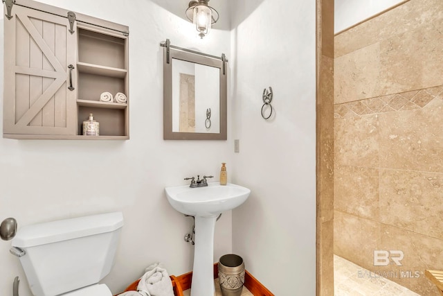 full bathroom featuring a tile shower and toilet