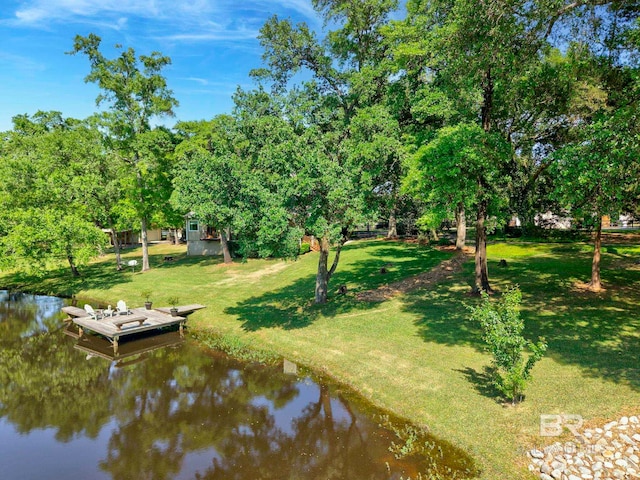 view of dock featuring a water view and a yard