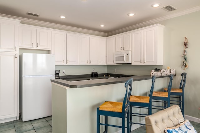 kitchen with white cabinetry, light tile patterned flooring, a breakfast bar, white appliances, and ornamental molding