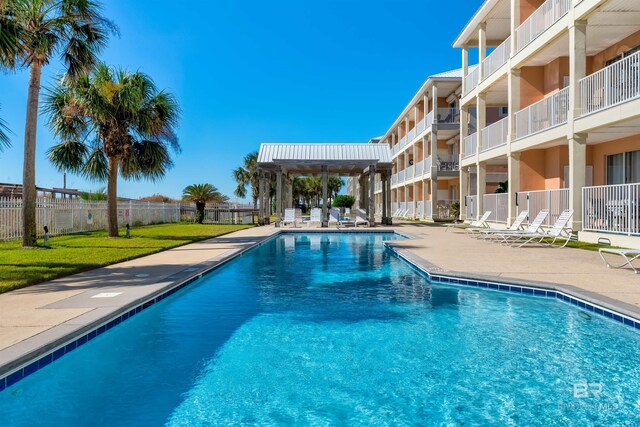 view of pool with a patio and a lawn