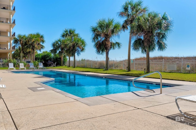 view of pool featuring a lawn and a patio