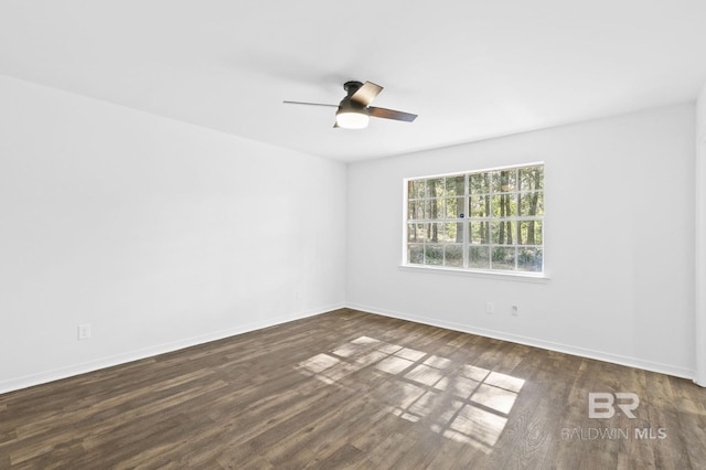 spare room with dark hardwood / wood-style flooring and ceiling fan