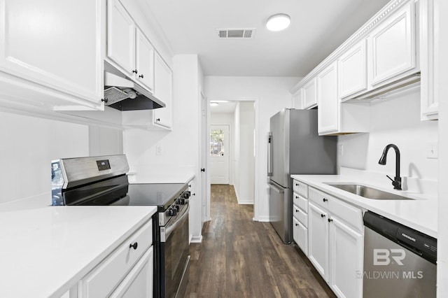 kitchen with sink, stainless steel appliances, dark wood-type flooring, and white cabinetry