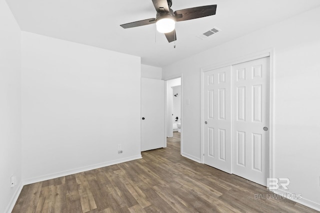 unfurnished bedroom with a closet, ceiling fan, and dark wood-type flooring