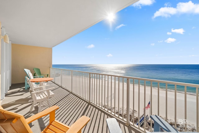 balcony featuring a water view and a beach view