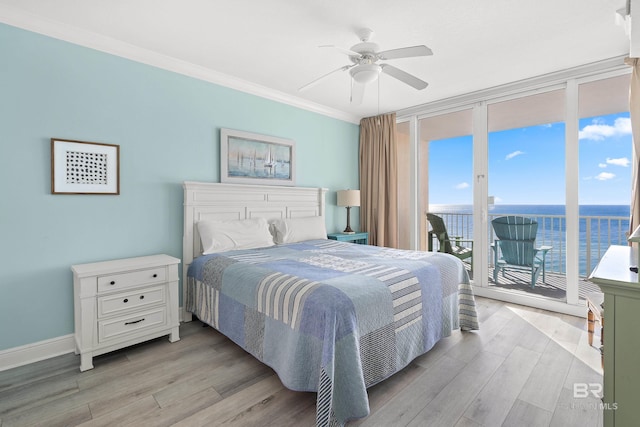 bedroom featuring light hardwood / wood-style flooring, ceiling fan, access to outside, a water view, and floor to ceiling windows