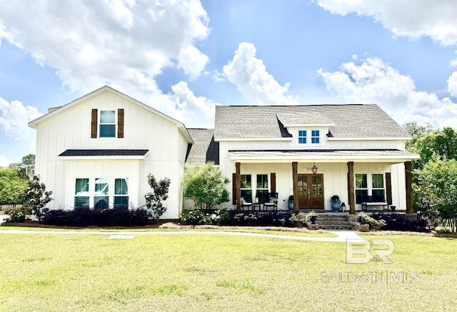 view of front of property with a front lawn, french doors, a shingled roof, board and batten siding, and a porch